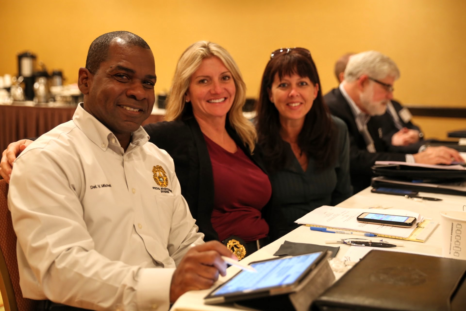 3 people seated at conference table