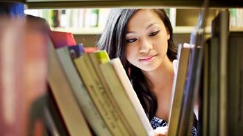 Student looking through books and student resources